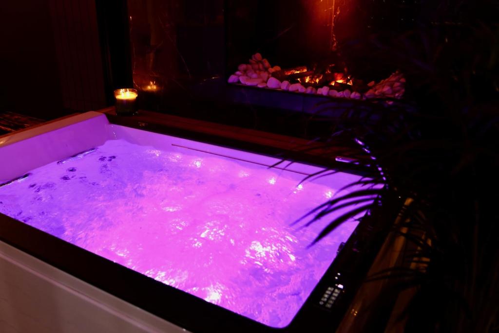 a hot pink bath tub with a candle in it at love room gold - les delices rooms in Angers