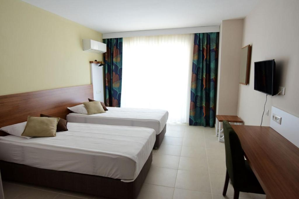 Habitación de hotel con 2 camas y TV en KALİYE ASPENDOS HOTEL en Antalya