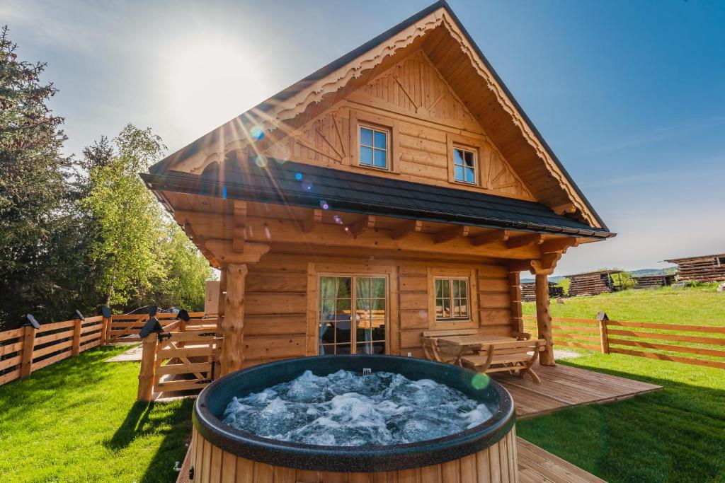 a log cabin with a hot tub in the yard at Pienińska Przystań in Kluszkowce
