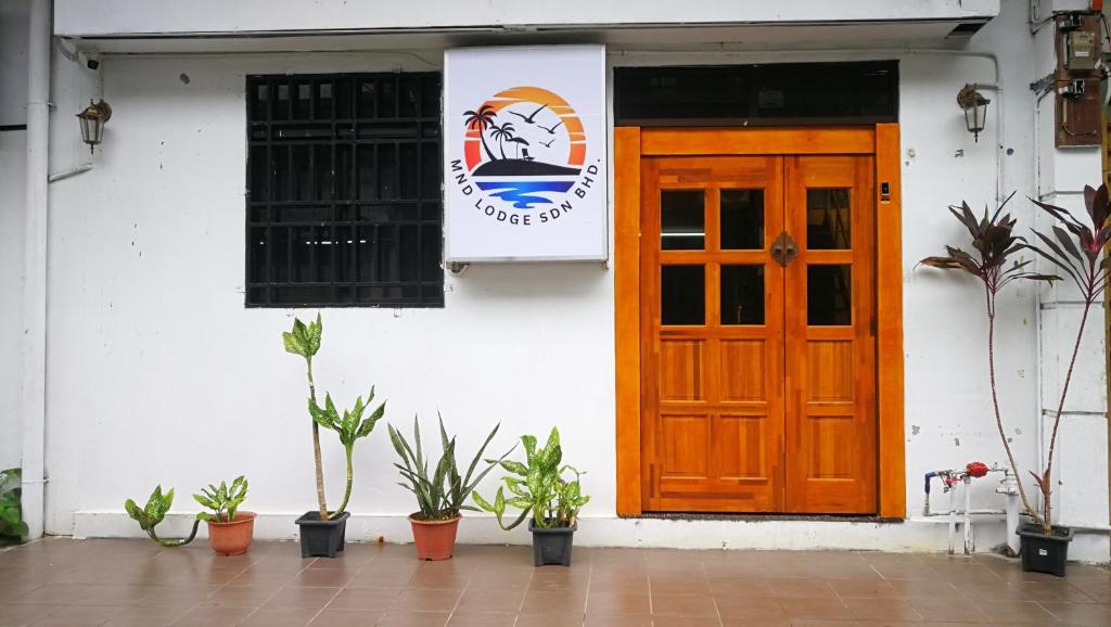 a building with a door and a sign on it at MnD Lodge in Semporna