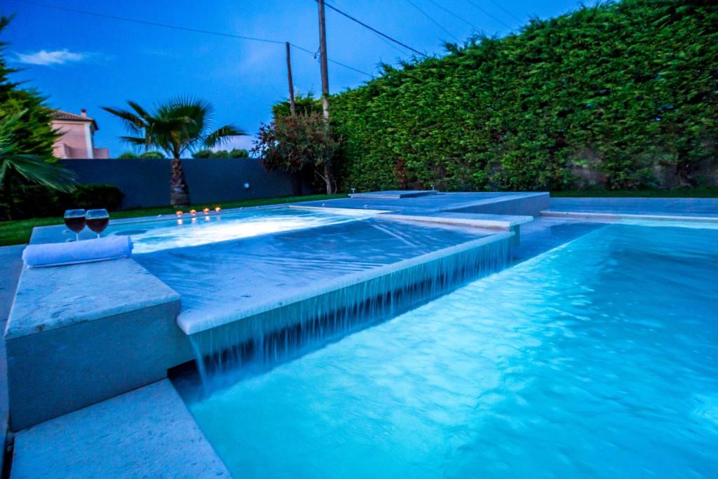 a swimming pool with blue water in a backyard at Palaz Villa in Ayios Kirikos