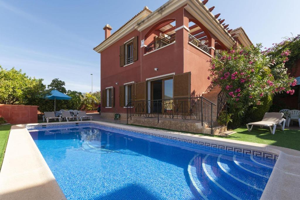 a villa with a swimming pool in front of a house at Casa Meli Finestrat in Finestrat