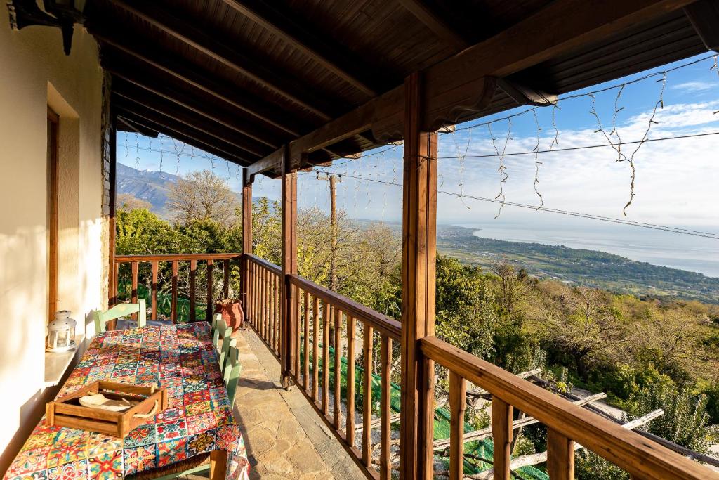 a balcony with a table and a view of the mountains at Halatsogiannis Mansion in Palaios Panteleimon