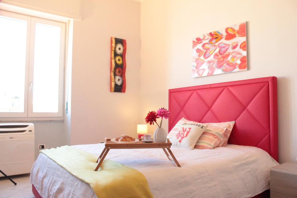 a bedroom with a pink bed with a table on it at Casa Tiziano in Cagliari