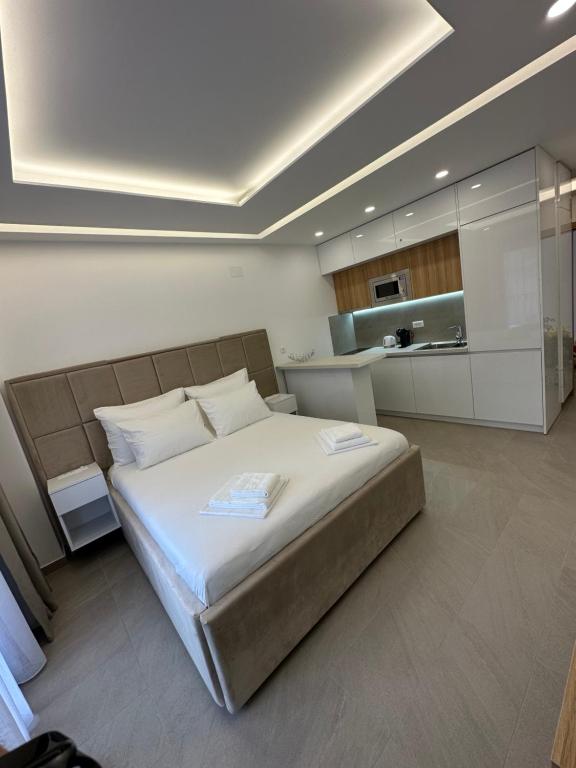 a bedroom with a large bed and a kitchen at Studio Apartman Dalia in Budva