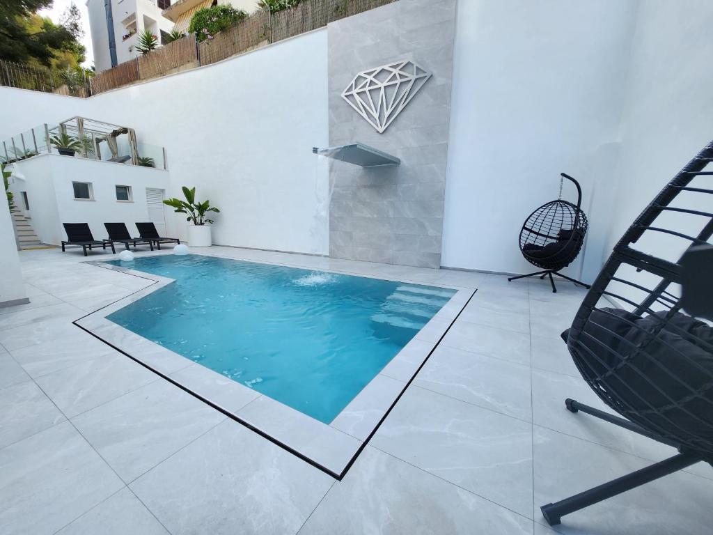 a swimming pool in the middle of a patio with a chair at Diamante Paguera Boutique Hotel in Paguera