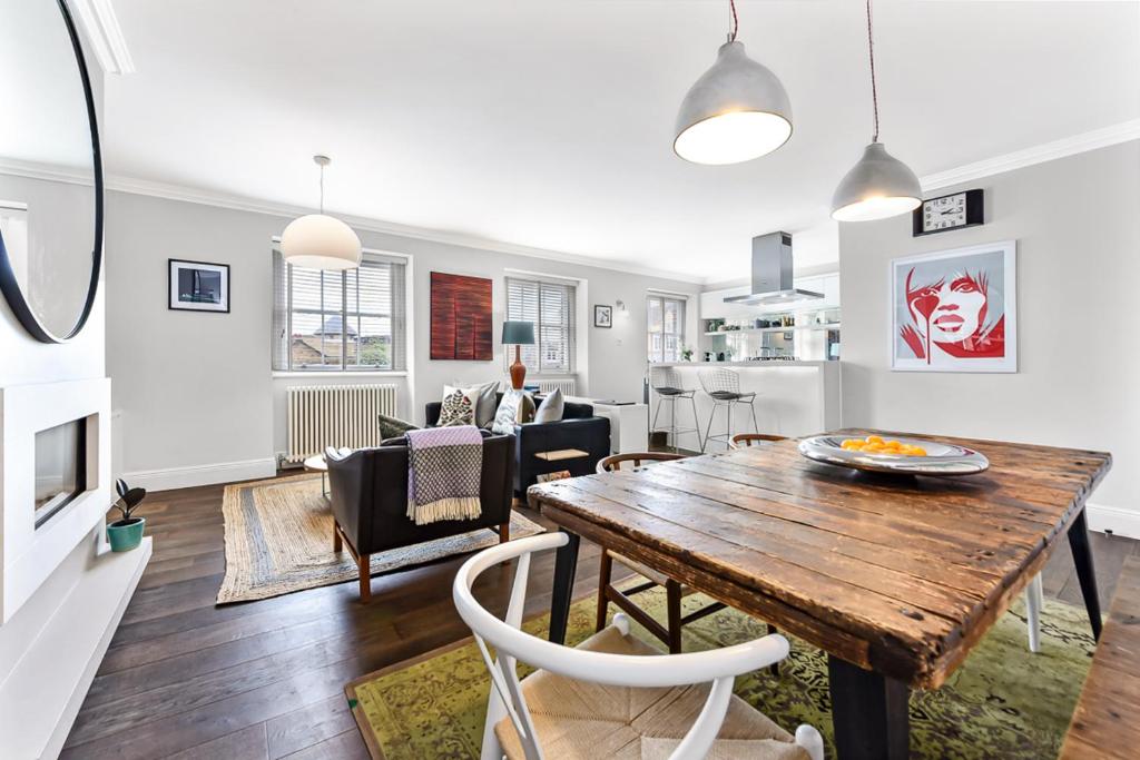 comedor y sala de estar con mesa de madera en Woodbridge House Apartment, en Londres