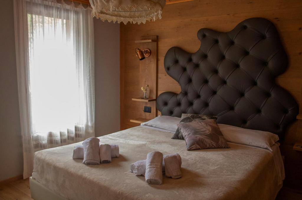 a bedroom with a large bed with towels on it at Al Mughetto in Auronzo di Cadore