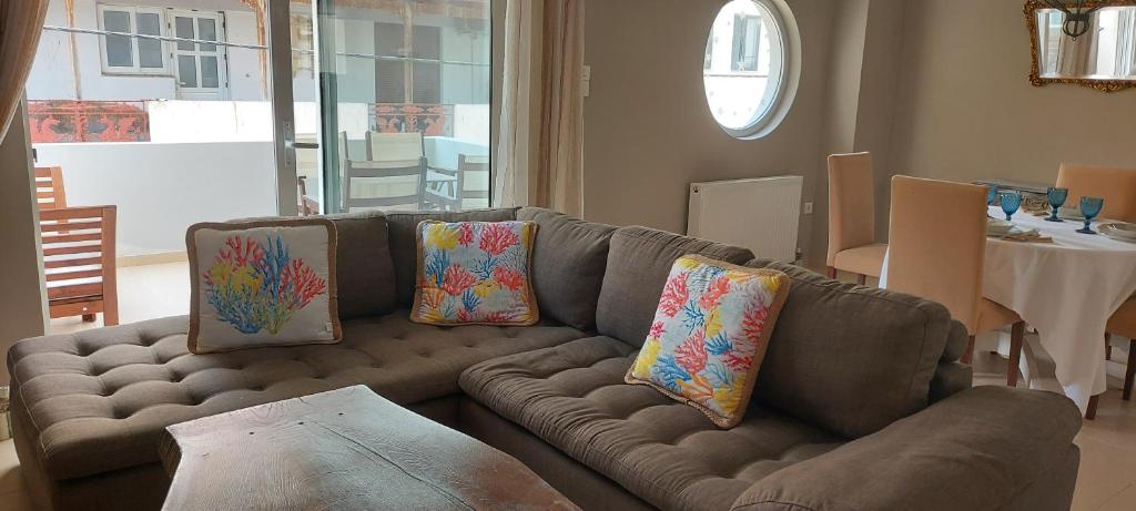 un soggiorno con divano marrone e cuscini di Momenti Felici a Artemida