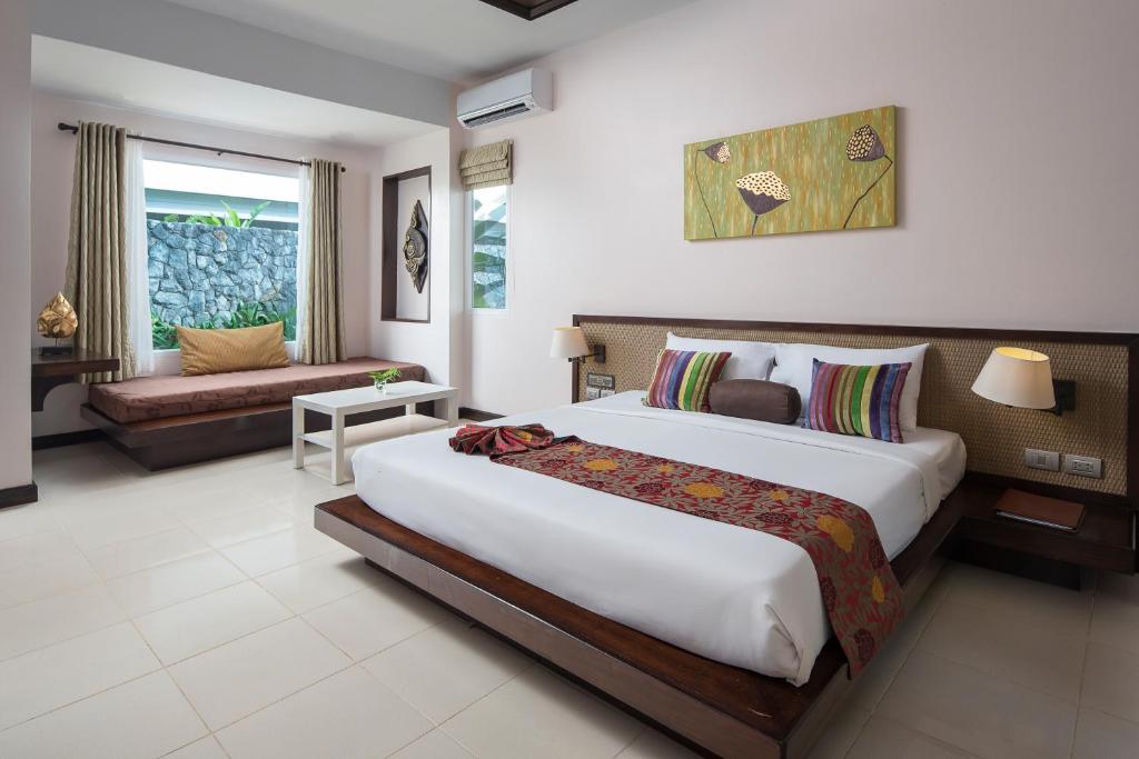 a bedroom with a large bed and a living room at Anyavee Tubkaek Beach Resort in Tab Kaek Beach