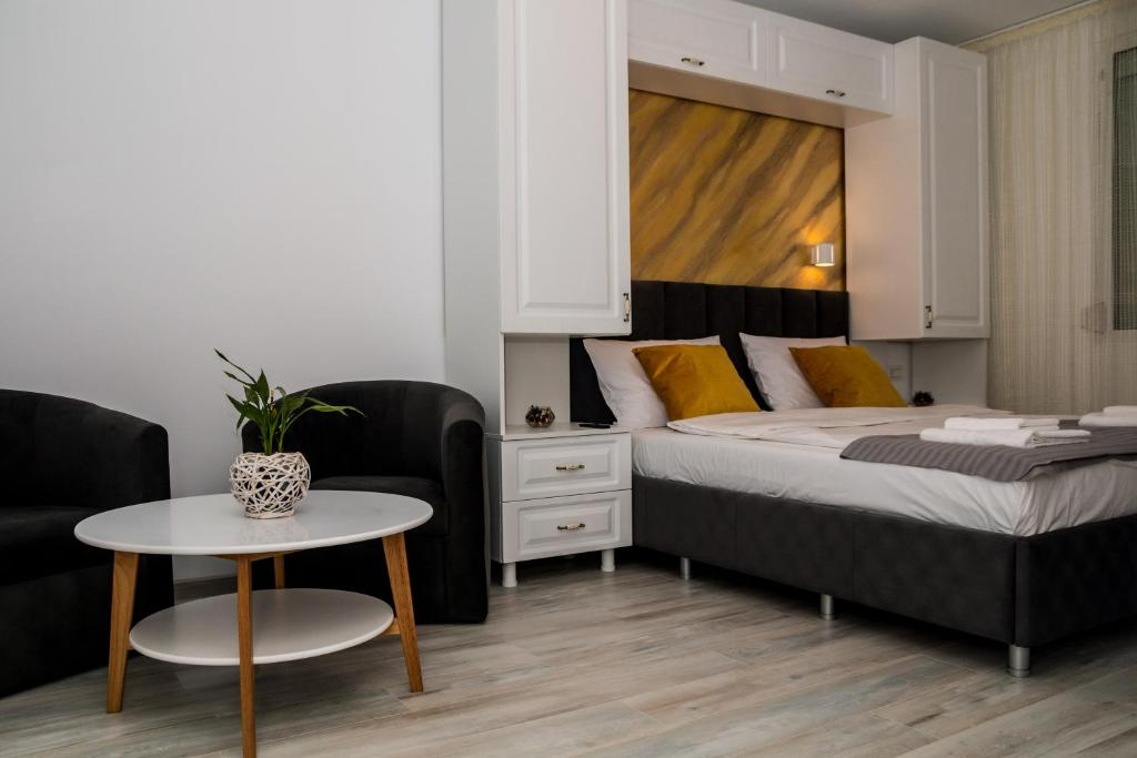 una camera con letto, tavolo e sedia di Apartament Zeuss Neptun a Neptun