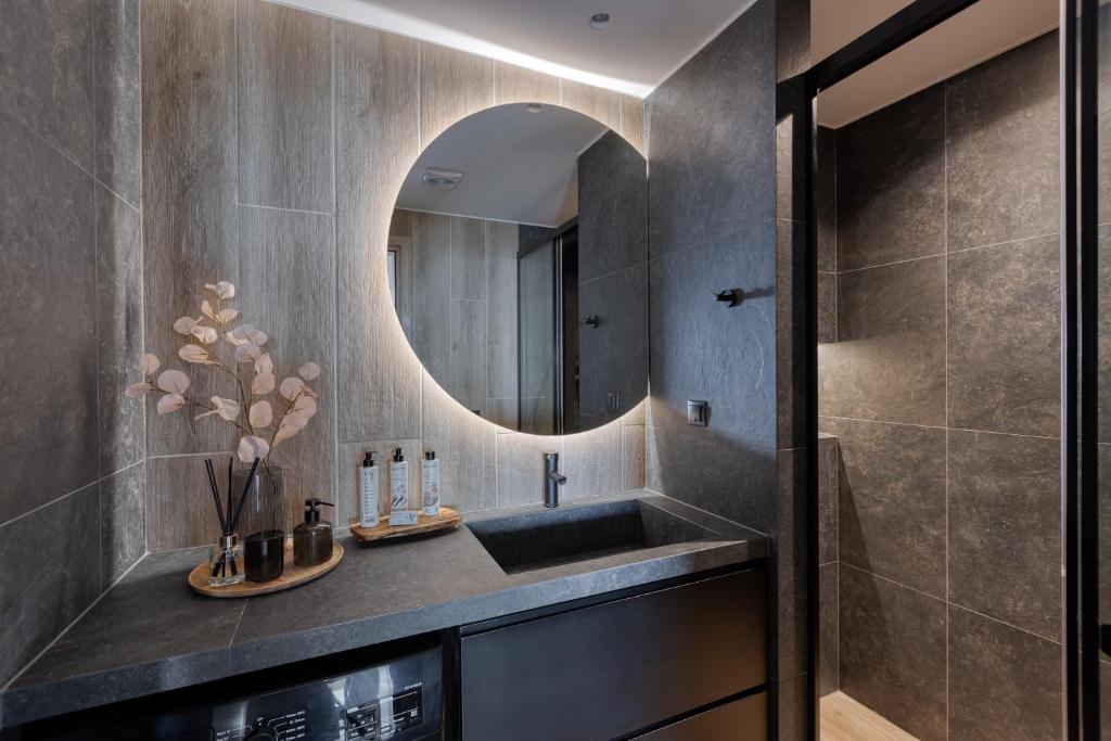 een badkamer met een wastafel en een spiegel bij Urban Zen in Agios Nikolaos