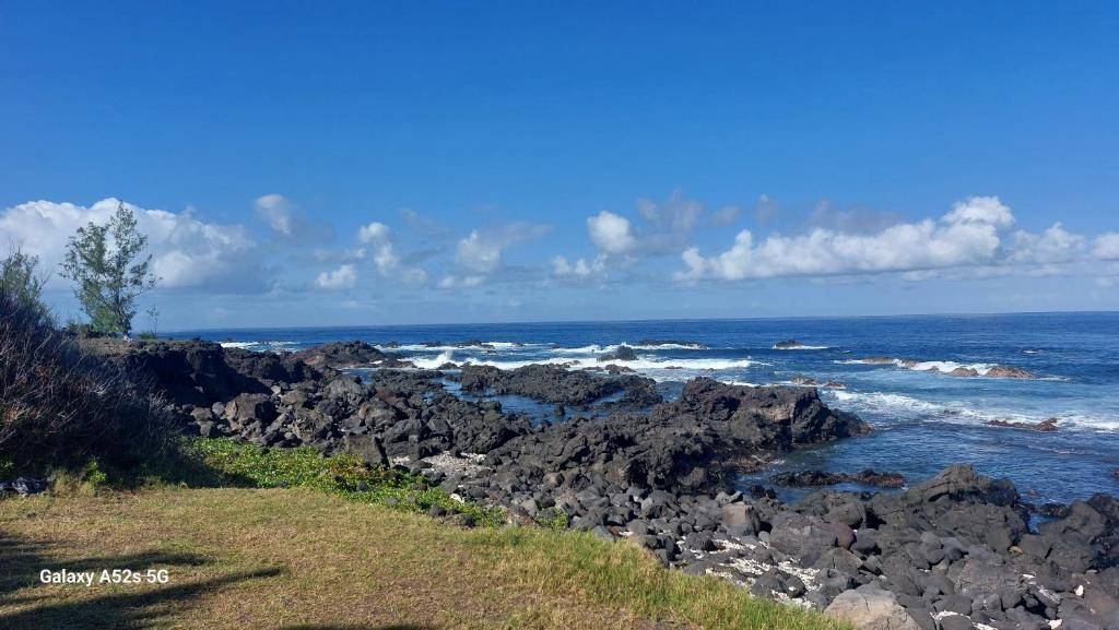 una playa rocosa con vistas al océano en RÊV BOR D'MER en Étang-Salé les Bains