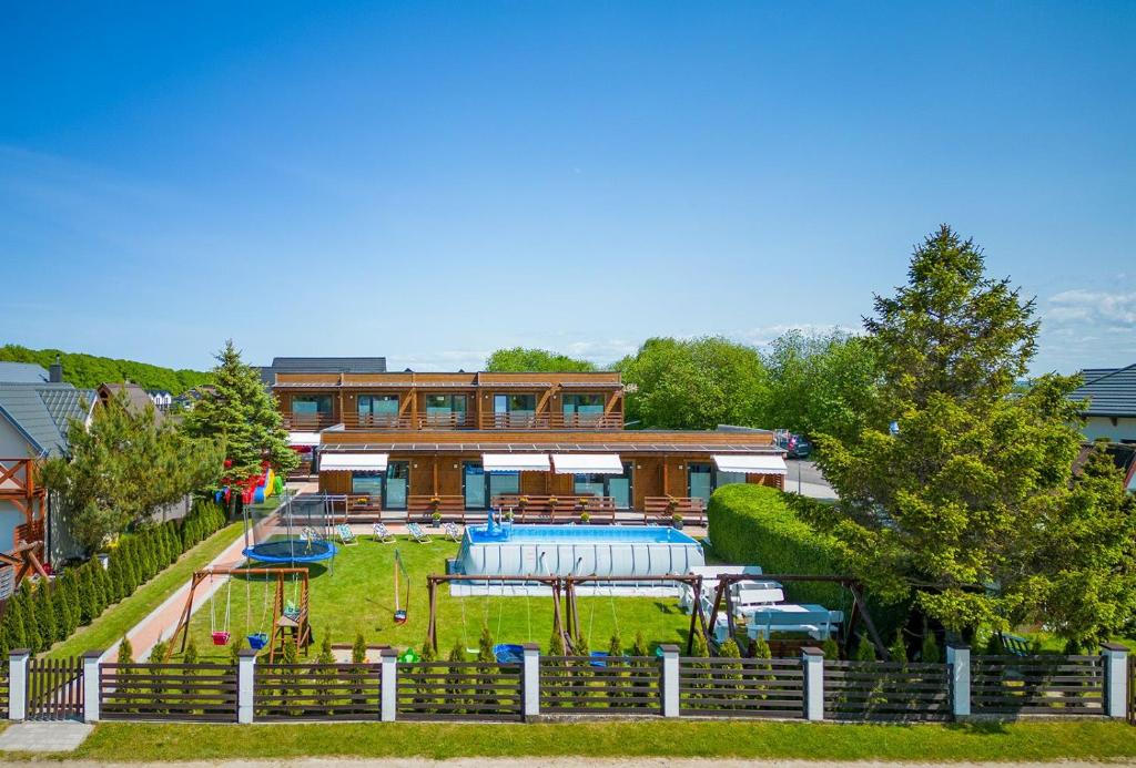 a park with a swimming pool and a playground at Baltic Resort in Mielno