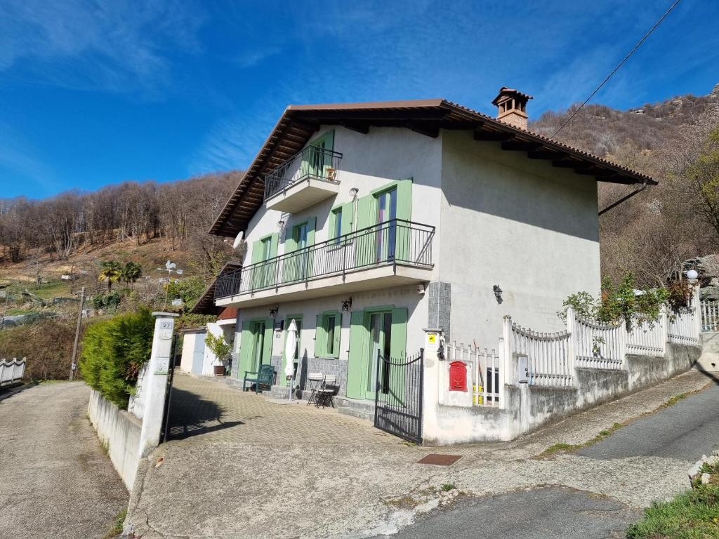 een wit en groen huis met een hek bij Casa Monte Bracco in Rifreddo
