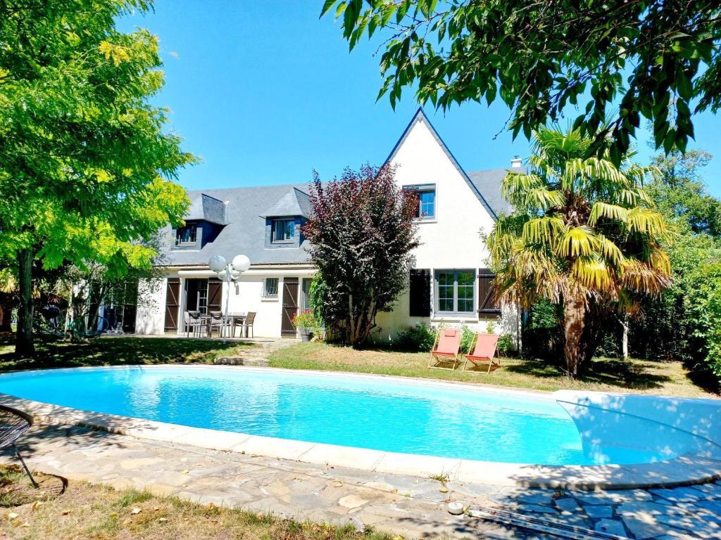 uma casa com piscina em frente a uma casa em Le Clos Beauséjour em Montjean-sur-Loire