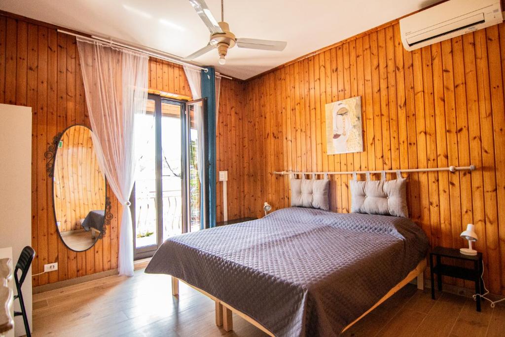 1 dormitorio con 1 cama con pared de madera en Yourquadrarooms B&b, en Roma