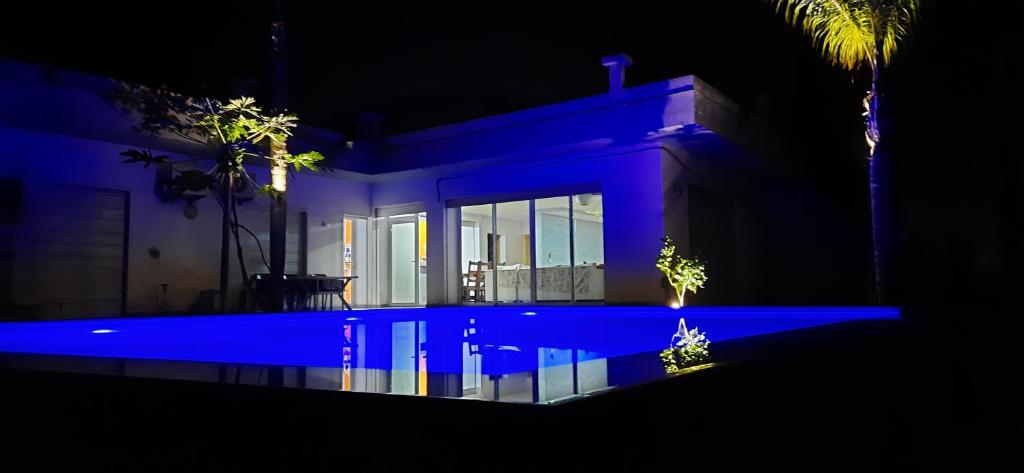 dom z niebieskim basenem w nocy w obiekcie l'avocatier w mieście Kenitra