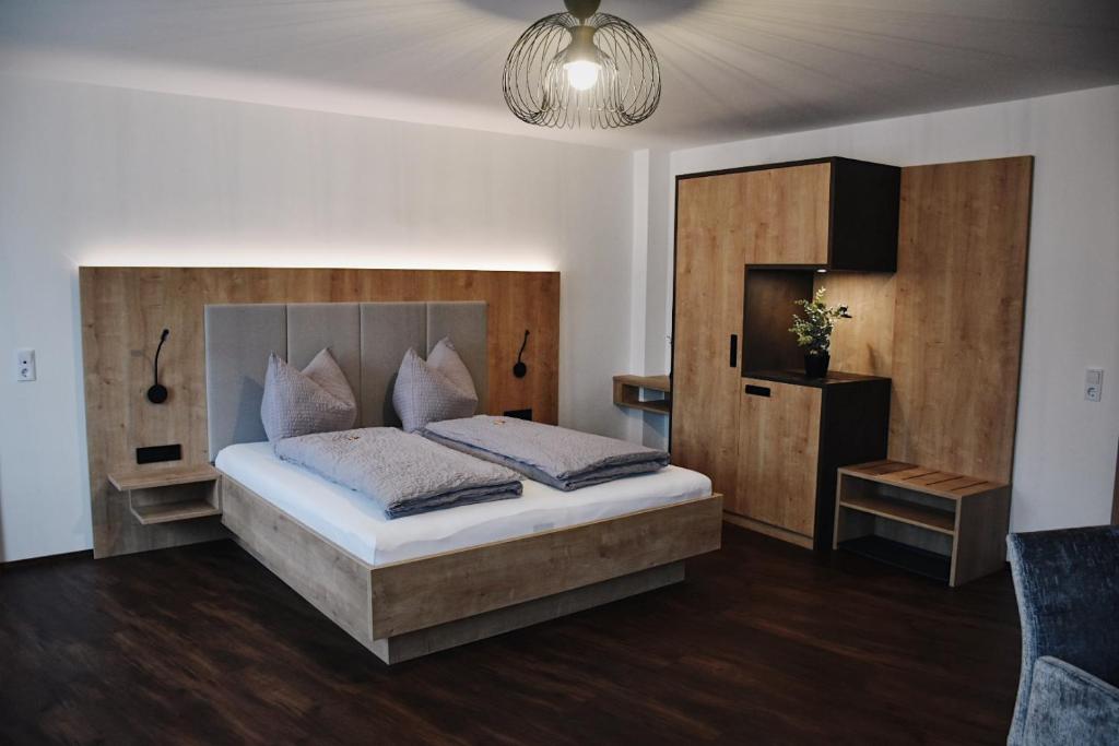 a bedroom with a bed with a wooden headboard at Das Joes Frühstückspension 