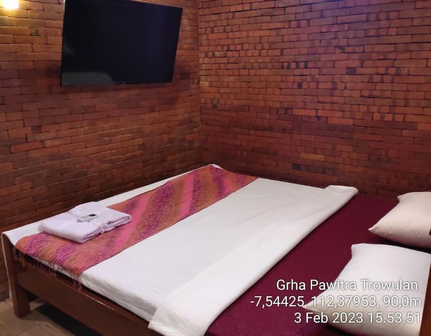 - un lit avec 2 serviettes assises au-dessus dans l'établissement GRHA PAWITRA TROWULAN, à Trowulan