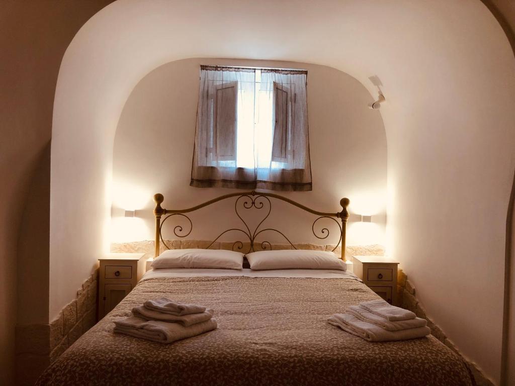 a bedroom with a bed with two towels on it at TRULLI DI ZIA TATA in Locorotondo