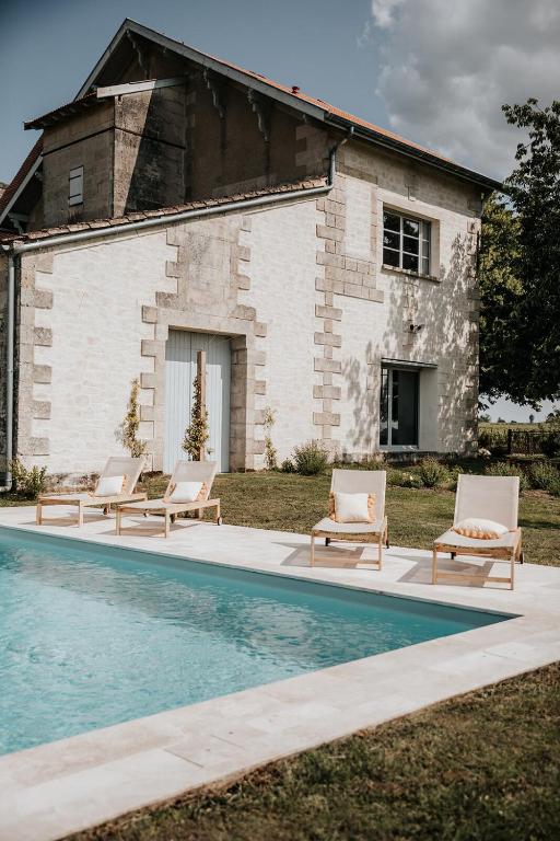 un groupe de chaises assises à côté d'une piscine dans l'établissement Château La Grande Clotte, à Lussac
