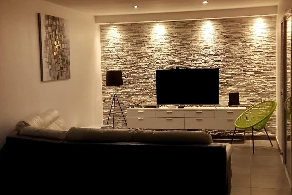 Il comprend un salon doté d'un canapé et d'une télévision à écran plat. dans l'établissement Sweet home 25mn du Puy du Fou, à Cholet