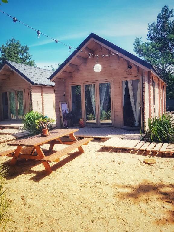 a picnic table in front of a log cabin at Sea You Soon w Sztutowie in Sztutowo
