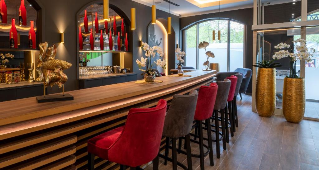 a bar in a restaurant with red chairs at PLAZA Premium Columbus Bremen in Bremen