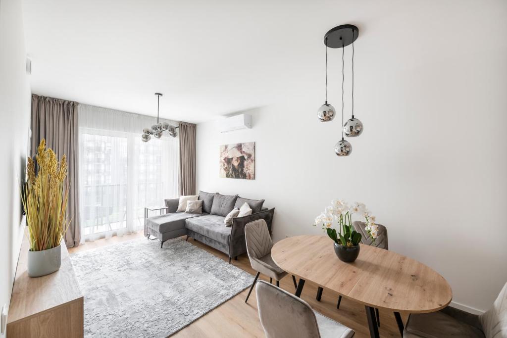 ein Wohnzimmer mit einem Tisch und einem Sofa in der Unterkunft Žalia kopa Metropolis Vilnius in Vilnius