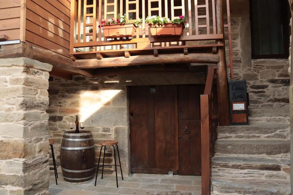 a wooden staircase with a wooden door and a barrel at Casa Fente in Taboada