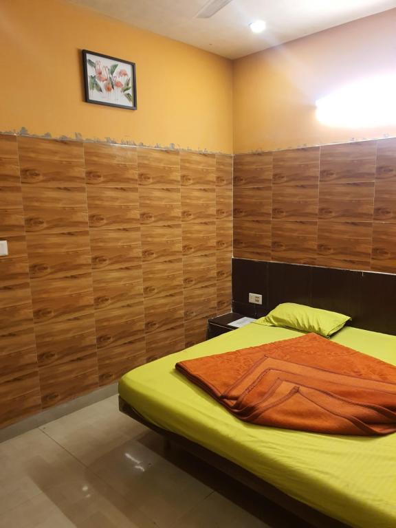 Un dormitorio con una cama y paredes de madera. en HOTEL YUVRAJ, en Haldwāni