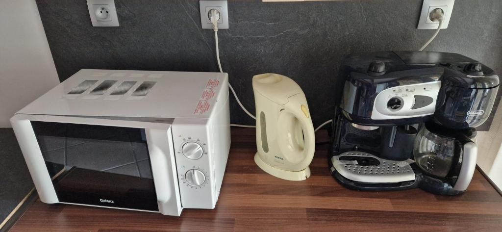 a microwave and a coffee maker next to a blender at La Grange de La Coste in Saint-Barthélemy-le-Meil