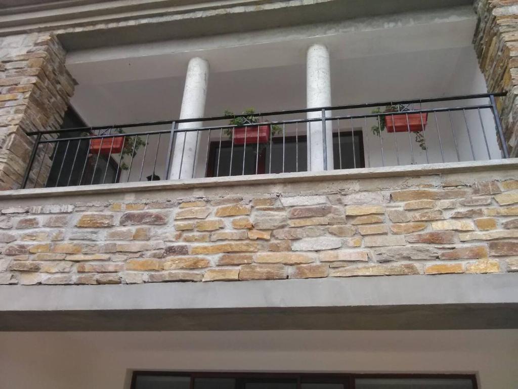 einen Balkon eines Gebäudes mit einer Steinmauer in der Unterkunft Къща за гости Поляна 