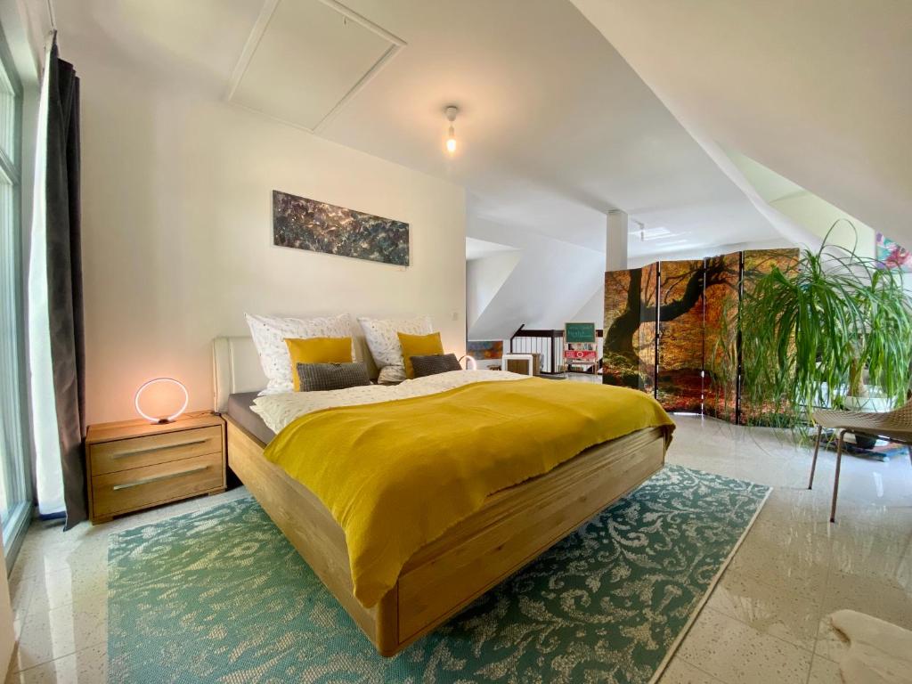 een slaapkamer met een groot geel bed en een tapijt bij Ferienhaus Ferienwohnung Potsdam DieGaLerie am Schlosspark Marquardt 