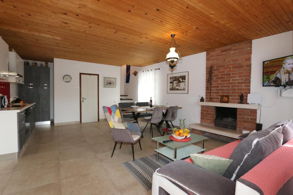 salon z kanapą i kominkiem w obiekcie House Zbasnik w mieście Klimno
