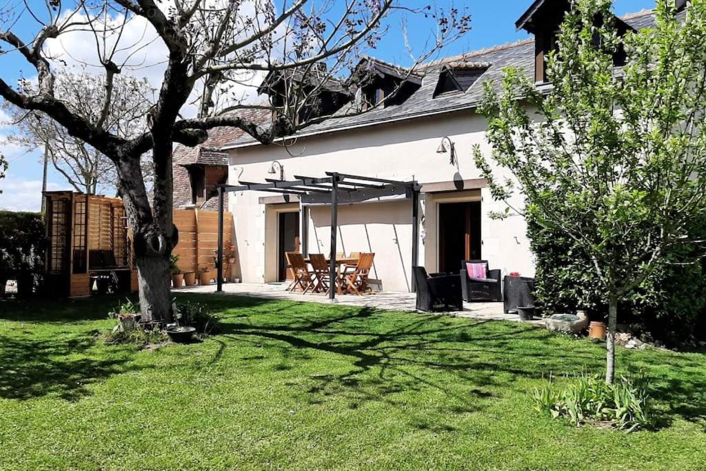 une maison blanche avec une cour arborée dans l'établissement Gîte Les Rimbaudières à Ligueil, à Ligueil