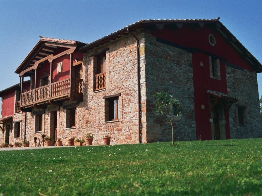 un gran edificio de ladrillo con balcón. en Apartamentos Rurales El Mirador de Cazanes, en Cazanes