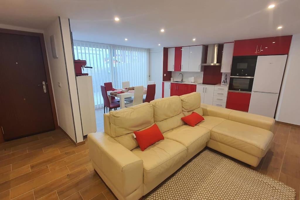 uma sala de estar com um sofá branco com duas almofadas vermelhas em HyP - A casa da Fina em Miño