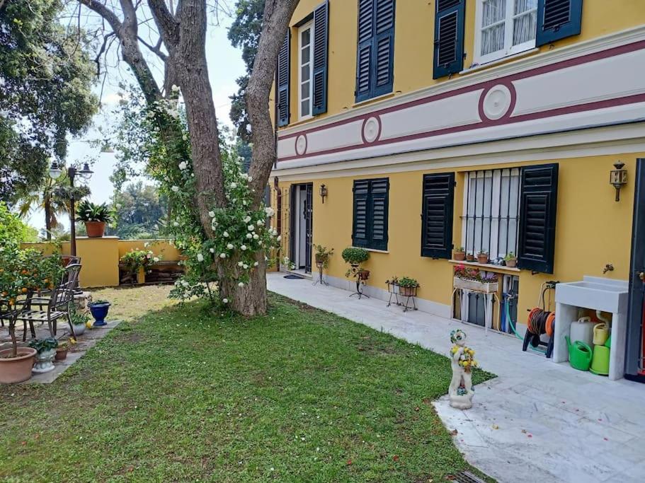 żółty dom z posągiem na podwórku w obiekcie Casetta Jacaranda w Genui