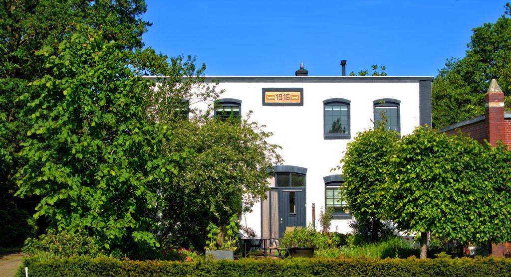 ein weißes Gebäude mit einem Schild darüber in der Unterkunft Sfeervolle bovenwoning uit 1916 met 2 slaapkamers in Hooghalen