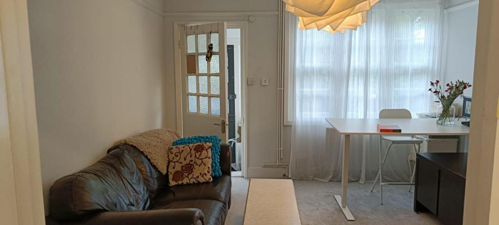 un soggiorno con divano e tavolo e una sala da pranzo di One Bedroom House in a Quiet Neighbourhood a Londra