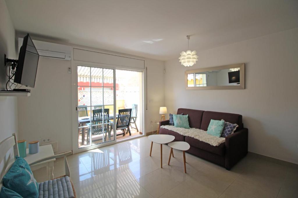 een woonkamer met een bank en een tafel bij Apart-rent Casa Puigmal 0152 in Empuriabrava