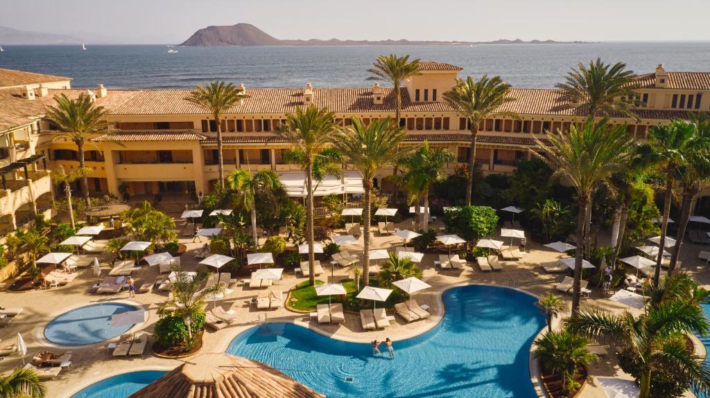 una vista aérea de un complejo con piscina y palmeras en Secrets Bahía Real Resort & Spa Adults only, en Corralejo