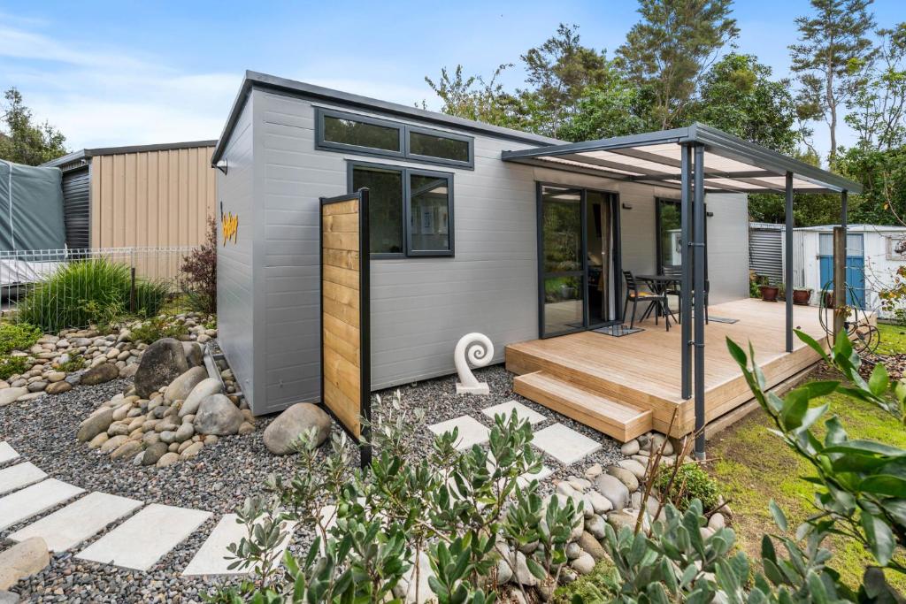 a tiny house with a deck and a patio at Birdsong - Turangi Holiday Unit in Turangi