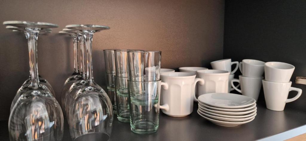 a group of glass vases and cups on a shelf at T2 neuf dans résidence avec piscine in Lecci