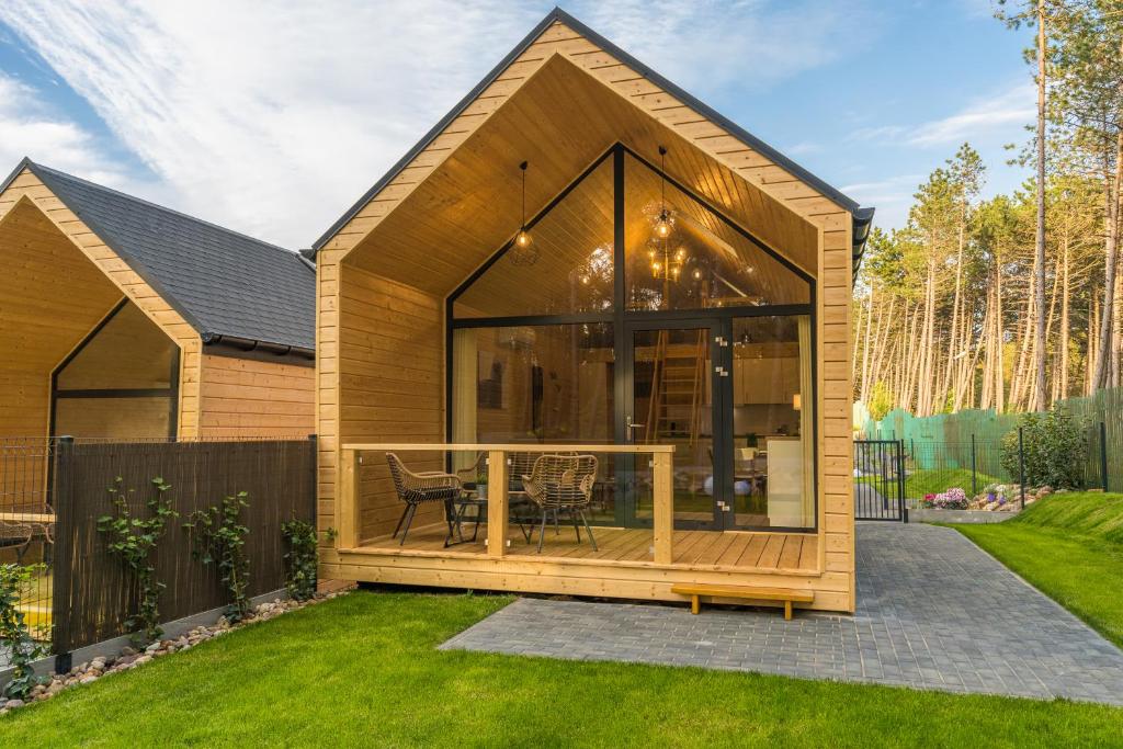 una pequeña casa con una gran fachada de cristal en Bursztynowo en Kąty Rybackie