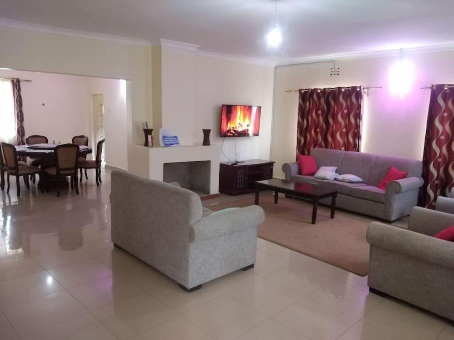 a living room with two couches and a dining room at La petals hideaway house Machakos in Machakos