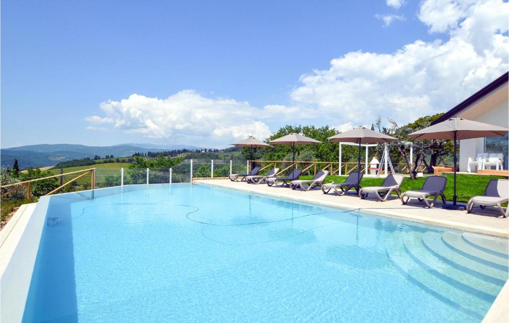 a large swimming pool with chairs and umbrellas at Beautiful Home In Arezzo With Outdoor Swimming Pool, Wifi And 6 Bedrooms in Arezzo