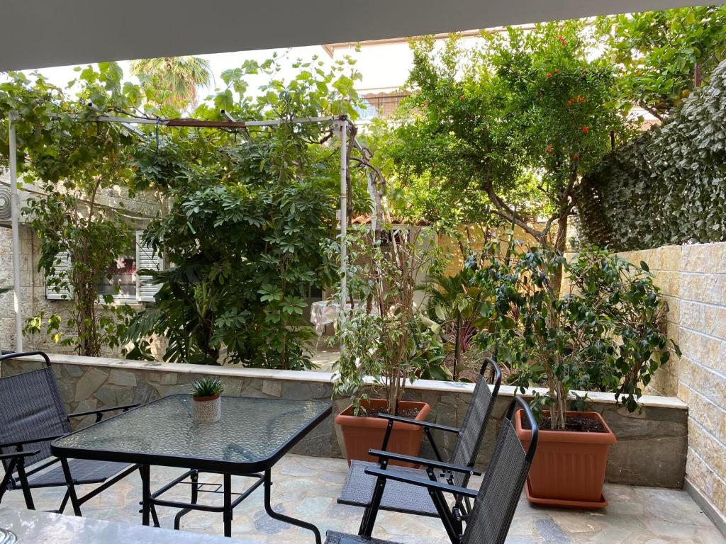 un patio con mesa, sillas y árboles en Garden View Apartment en Athens